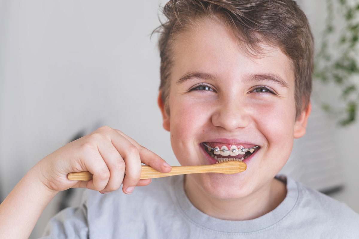 Bambino che si lava i denti mentre sorride